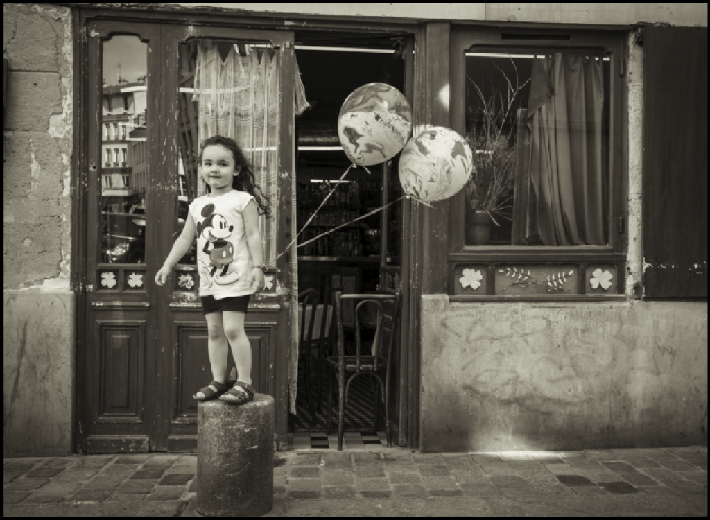 BLACKRAPID Guest Post by Christopher Broughton | Christopher Broughton Photography 6 This little girl was running down the street and jumped up on the pillar with her balloons, full of energy, and turned toward me. When the camera was seen... you get it.